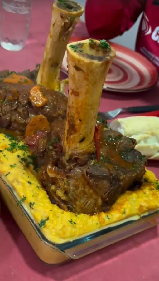 Dos ossobucos servidos en fuente sobre una mesa lista para compartir