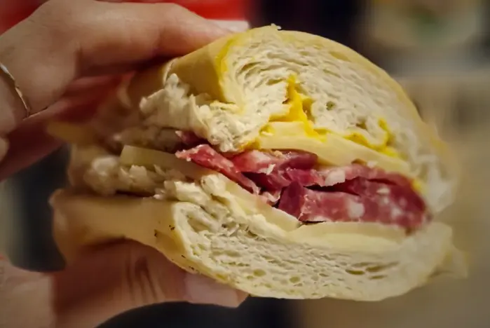 Sánguche de pan francés con salame y queso, cortado al medio